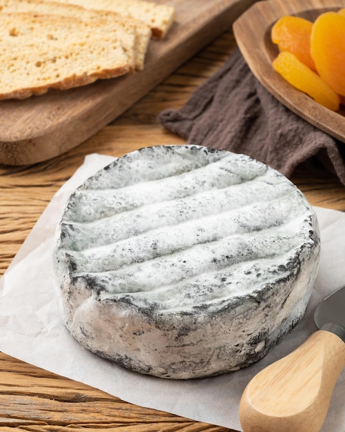 Queijo artesanal brasileiro lua cheia com torradas e frutas sobre mesa de madeira