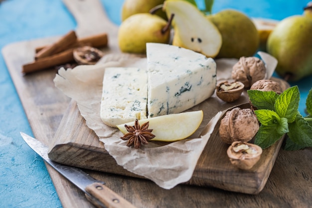 Queijo azul italiano picante Gorgonzola, feito com leite de vaca não desnatado no norte da Itália. Pedaço de queijo de mofo azul danablu, roquefort com pêra e nozes