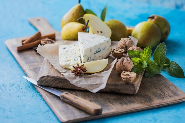 Queijo azul italiano picante Gorgonzola, feito com leite de vaca não desnatado no norte da Itália. Pedaço de queijo de mofo azul danablu, roquefort com pêra e nozes