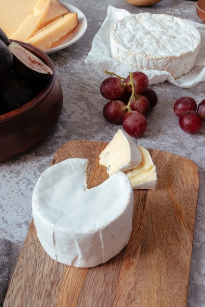 Queijo azul pequeno cortado com uvas vermelhas