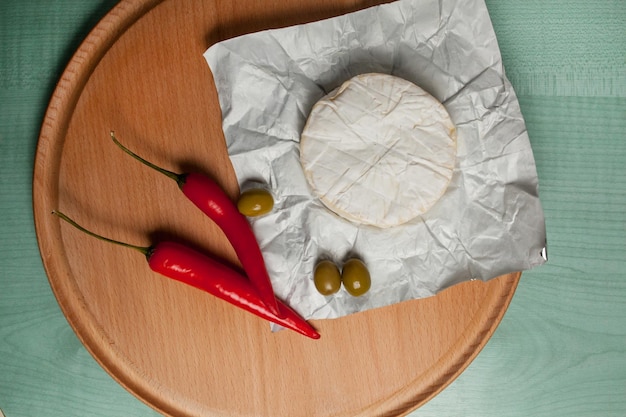 queijo brie camembert azeitonas pimentão em uma vista superior de fundo claro de madeira Queijo camembert