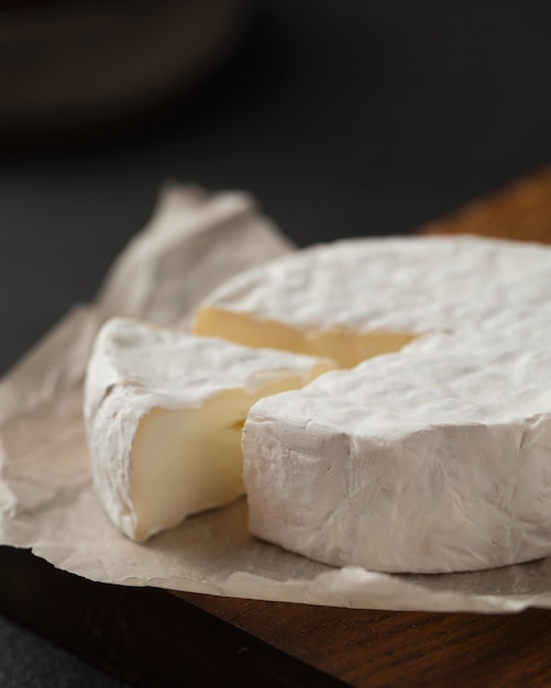 Queijo brie em uma placa de madeira Um pedaço de camembert cozinha francesa Aperitivo