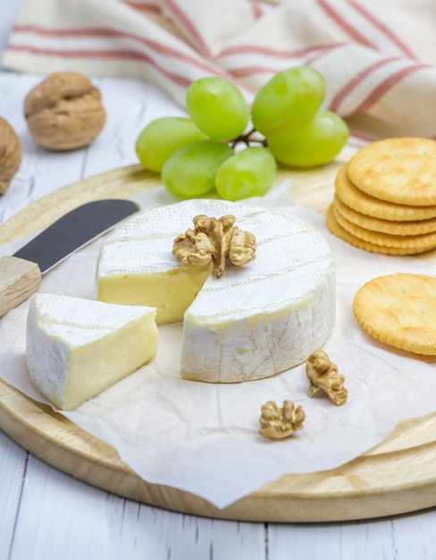 Queijo brie macio com uvas doces, nozes e biscoitos