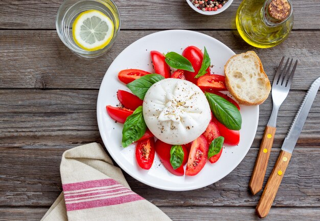 Queijo burrata italiano com tomate e manjericão. Salada. Alimentação saudável. Comida vegetariana.