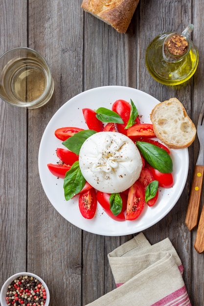 Queijo burrata italiano com tomate e manjericão. Salada. Alimentação saudável. Comida vegetariana.