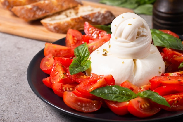 Queijo burrata tradicional italiano com salada de delicioso tomate cereja, folhas de manjericão e azeite