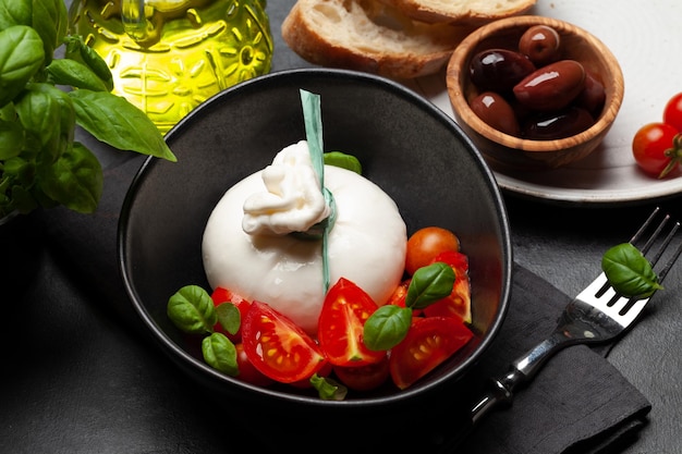 Queijo Burrata vários tomates e azeitonas