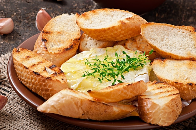 Queijo Camembert assado com tomilho e torradas esfregadas com alho