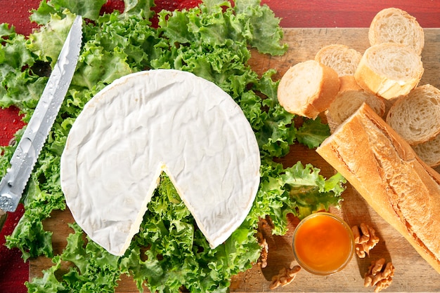 Queijo camembert em salade verde com tigela de mel e baguete de pão