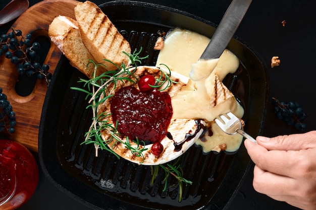 Queijo camembert em uma frigideira com nozes e alecrim