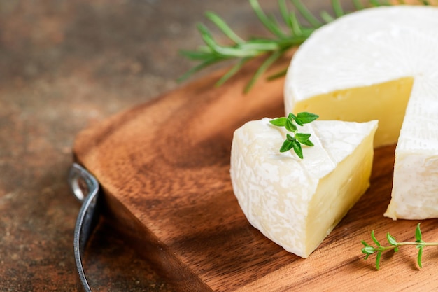 Queijo Camembert fatiado com tomilho na chapa de madeira Camembert é um creme macio e úmido