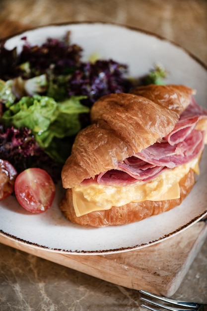 Queijo cheddar de presunto e croissant francês recheado com ovo mexido closeup