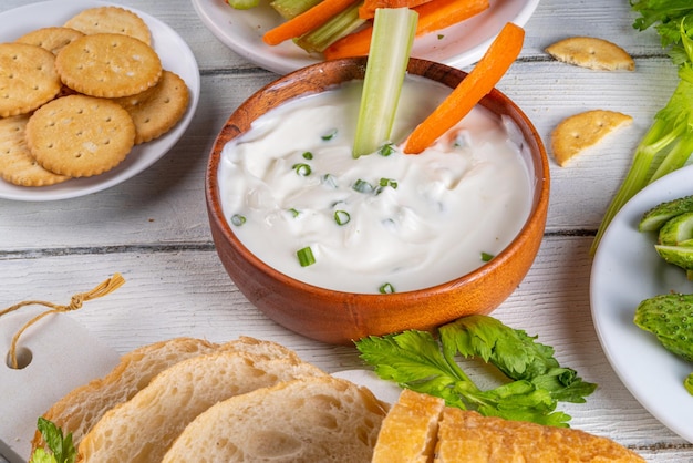 Queijo cottage highprotein dip com legumes frescos pão e biscoitos em madeira branco mesa espaço de cópia comer dieta saudável queijo curd espalhar com vários lanches