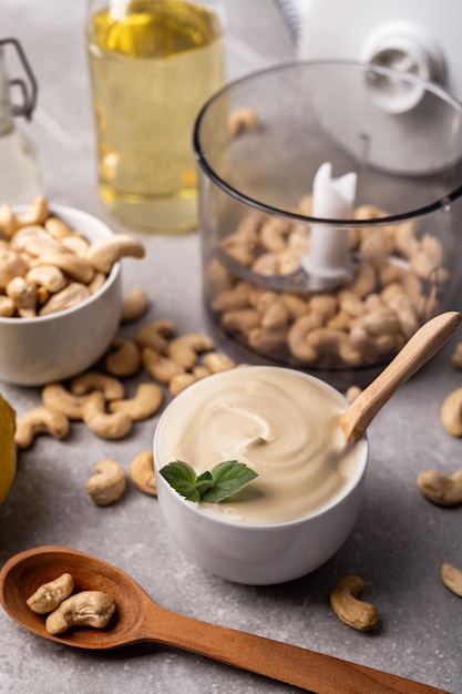 Foto queijo creme de castanha de caju em uma tigela branca e ingredientes de cozinha