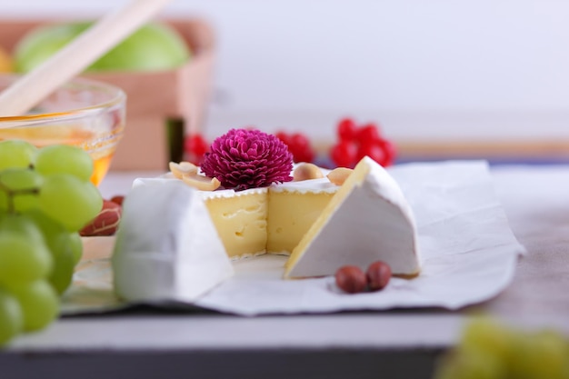 Queijo creme francês Camembert feito de leite de vaca servido com mel e frutas Comida para um lanche saudável e saboroso em um fundo branco Detalhe