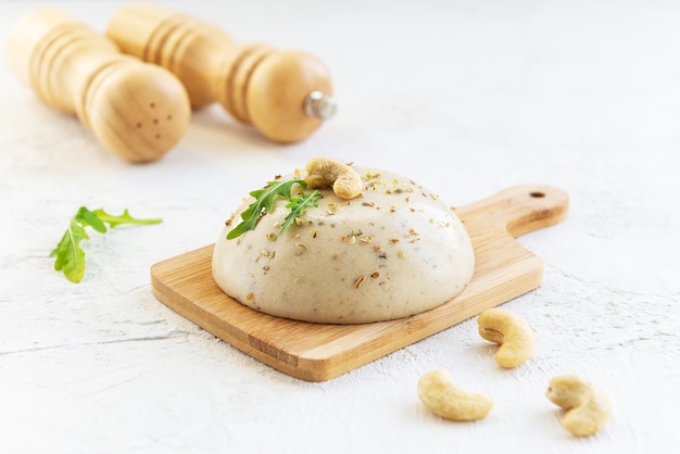 Queijo de caju vegan com temperos em uma placa de madeira