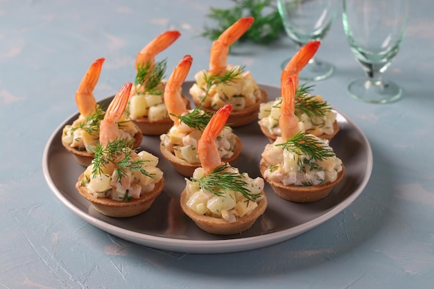 Queijo de camarão e tortinhas de abacaxi um lanche festivo em um fundo azul