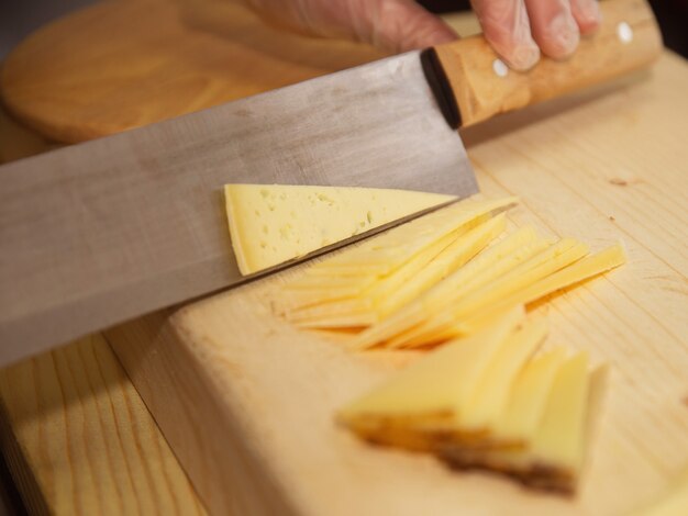 queijo de diferentes variedades em um fundo de madeira natural inteiro e cortado