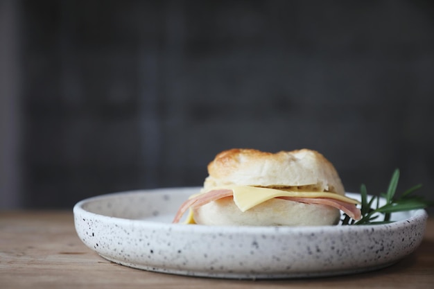 Queijo de presunto bagel em close-up no fundo de madeira na cafeteria