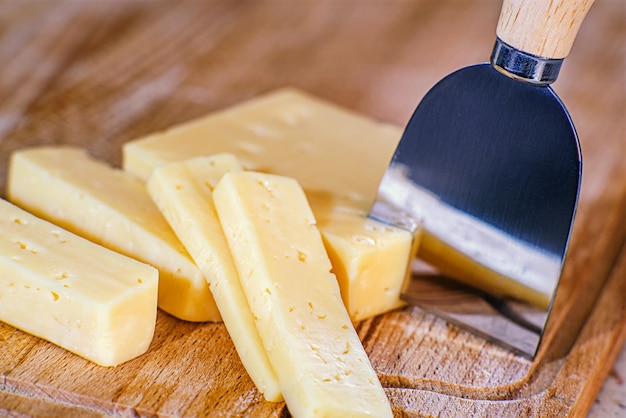 Queijo duro em uma placa com uma faca de queijo, o conceito de alimentação saudável. Cozinhar Parmesão. Vista do topo.