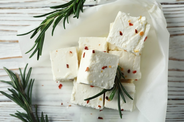 Queijo feta com especiarias e alecrim em madeira branca