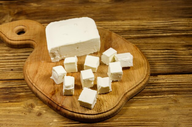 Queijo feta na tábua sobre uma mesa de madeira