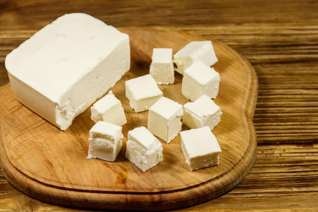 Queijo feta na tábua sobre uma mesa de madeira