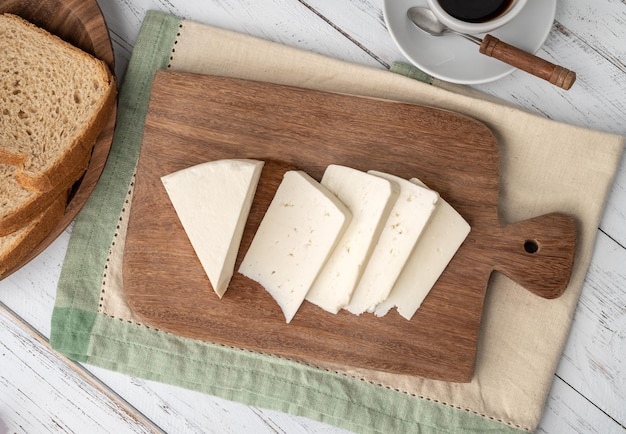 Queijo fresco artesanal de Canastra com café e pão sobre tábua de madeira