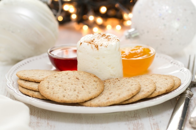 Queijo fresco com biscoitos e geléia no prato branco