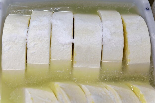 Foto queijo jovem gruyere de comte em tigela com sal em laticínios franche comte na borgonha, na frança.