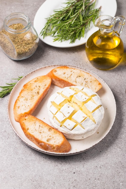 Queijo macio camembert assado. Brie grelhado com torradas e alecrim.