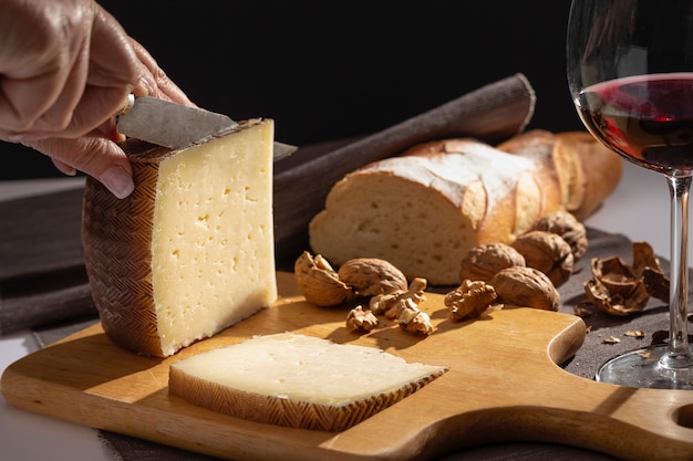 Queijo Manchego e nozes na mesa de madeira.