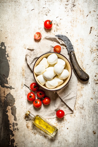 Queijo mussarela, tomate, azeite e uma faca velha.