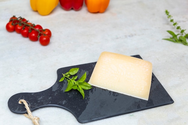 Queijo parmesão no tabuleiro de pedra preta com especiarias