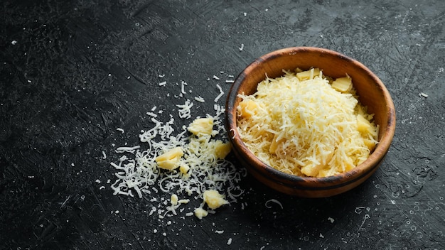 Queijo parmesão ralado em uma tigela Queijo Vista superior Em um fundo de pedra