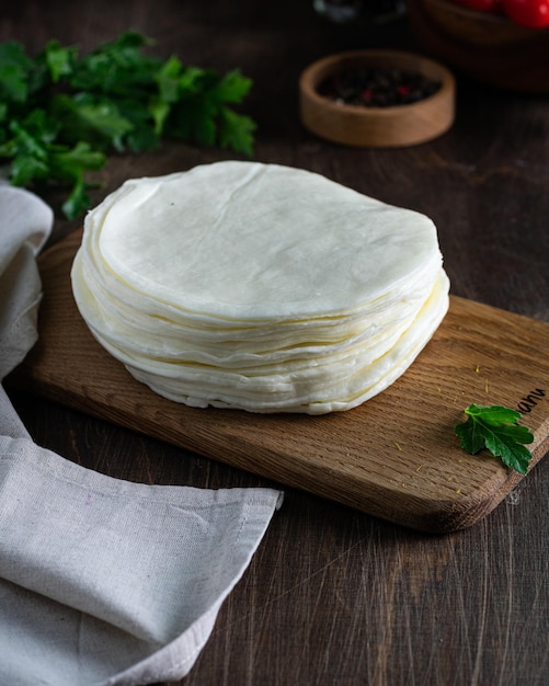 Queijo Suluguni com salsa em uma tábua de madeira Foco seletivo vertical