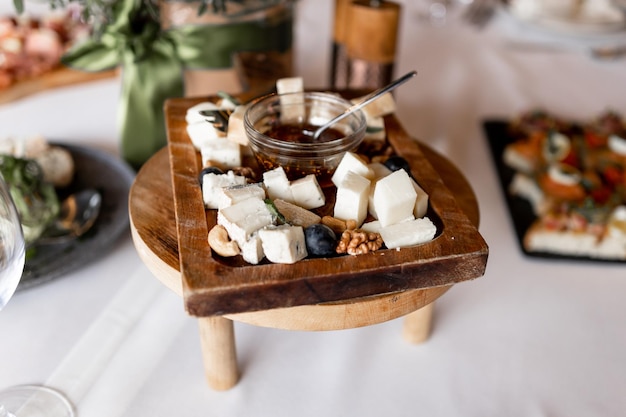 Queijos fatiados em uma placa de madeira em um restaurante na mesa