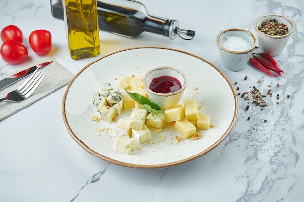 Queijos variados de dar água na boca: dorblu, parmesão, queijos de pasta mole, servidos em um prato branco com uvas e mel