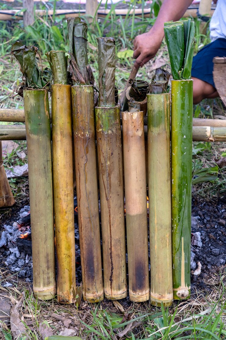 Foto queima de arroz de bambu na culinária tradicional, comida asiática. ubud, ilha de bali, indonésia. fechar-se. arroz pegajoso queimado com leite de coco doce em uma dose de bambu