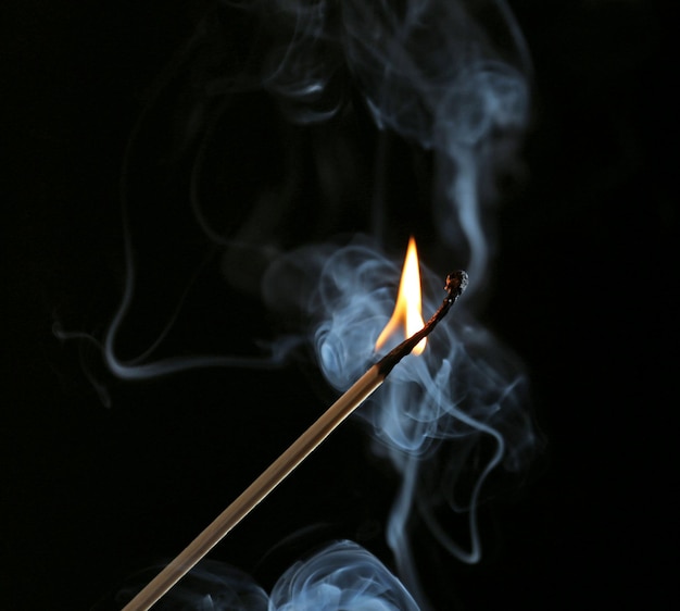 Foto queima de fósforo em fumaça em fundo escuro