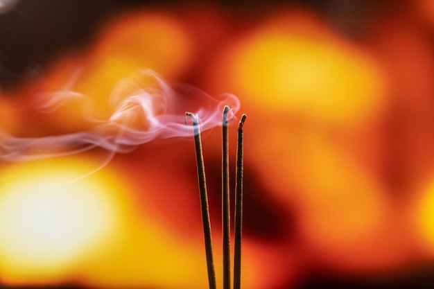 Queima de incenso varas com fumaça, incenso queimando em um templo budista vintage