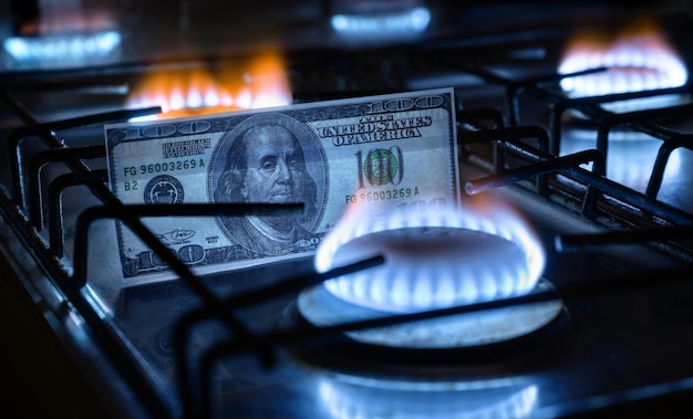Queimadores de gás e notas de dólar dos EUA dinheiro dos EUA no fogão a gás doméstico