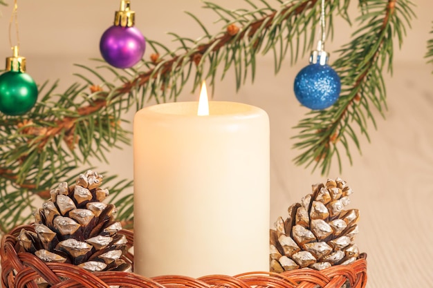 Queimando cones de velas e galhos de árvores de abetos naturais com bolas de Natal