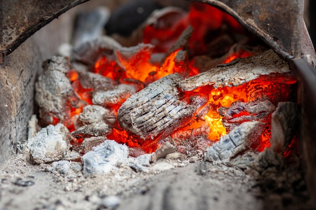 Quema de carbones en una parrilla metálica para freír carnes y verduras. Cocinar en una fogata.