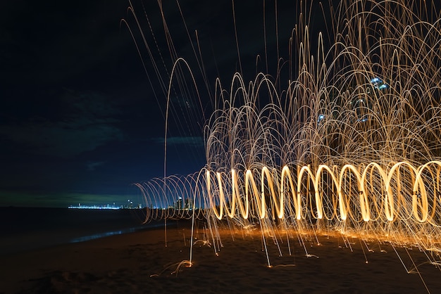 Foto quema de fuegos artificiales de lana de acero en el mar.