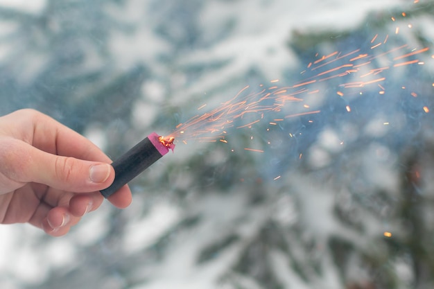 Quema de petardos en una mano chispas y humo de petardo