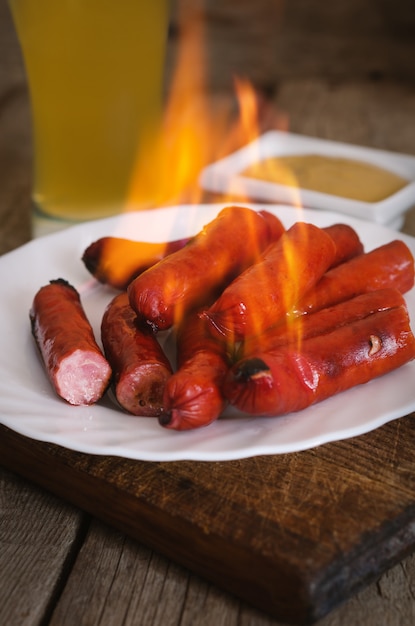 Foto quema de salchichas en un plato con salsa de mostaza