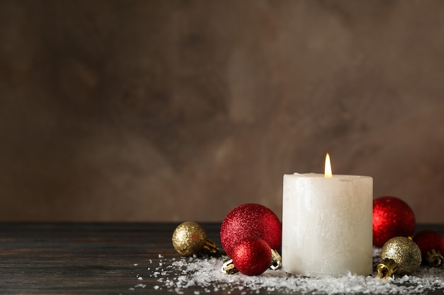 Quema de velas y bolas de navidad en madera con nieve