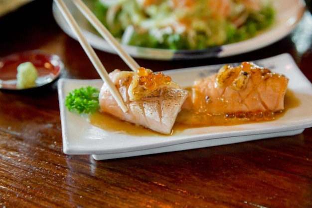 Quemar cobertura de salmón de sushi con enfoque selectivo de camarones de huevo