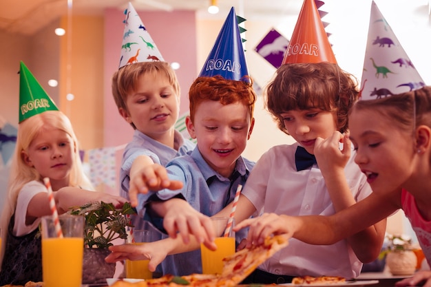 Quer comer. crianças encantadas expressando positividade durante o jantar